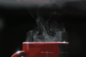 Steaming red mug against a dark background.